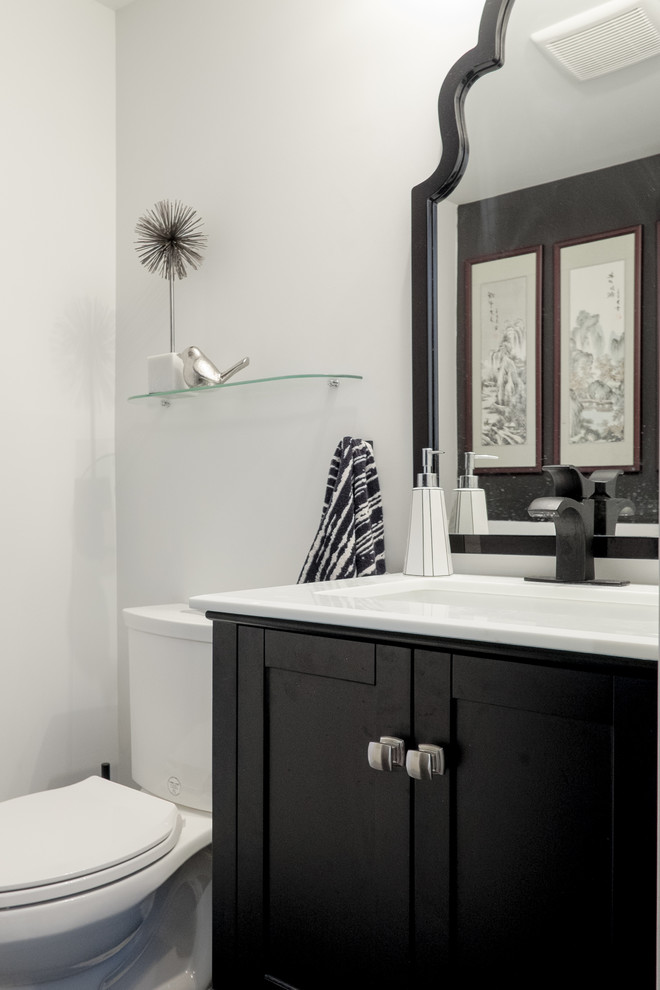 Aménagement d'un petit WC et toilettes classique avec un placard en trompe-l'oeil, des portes de placard noires, WC séparés, un mur blanc, un sol en carrelage de céramique, un lavabo posé et un sol noir.