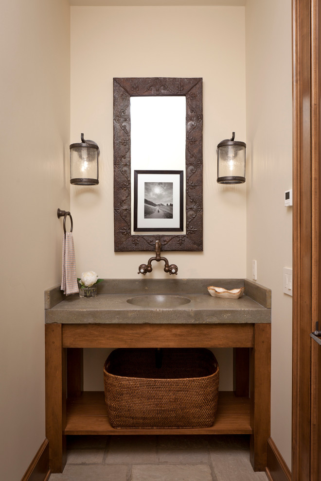 Mid-sized mountain style powder room photo in Other with an integrated sink, concrete countertops, beige walls and gray countertops