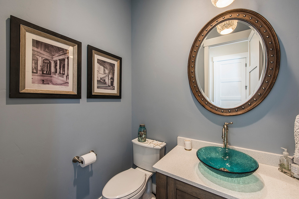 Aménagement d'un petit WC et toilettes classique en bois brun avec un placard avec porte à panneau encastré, WC séparés, un mur gris, une vasque, un plan de toilette en quartz modifié et un plan de toilette blanc.