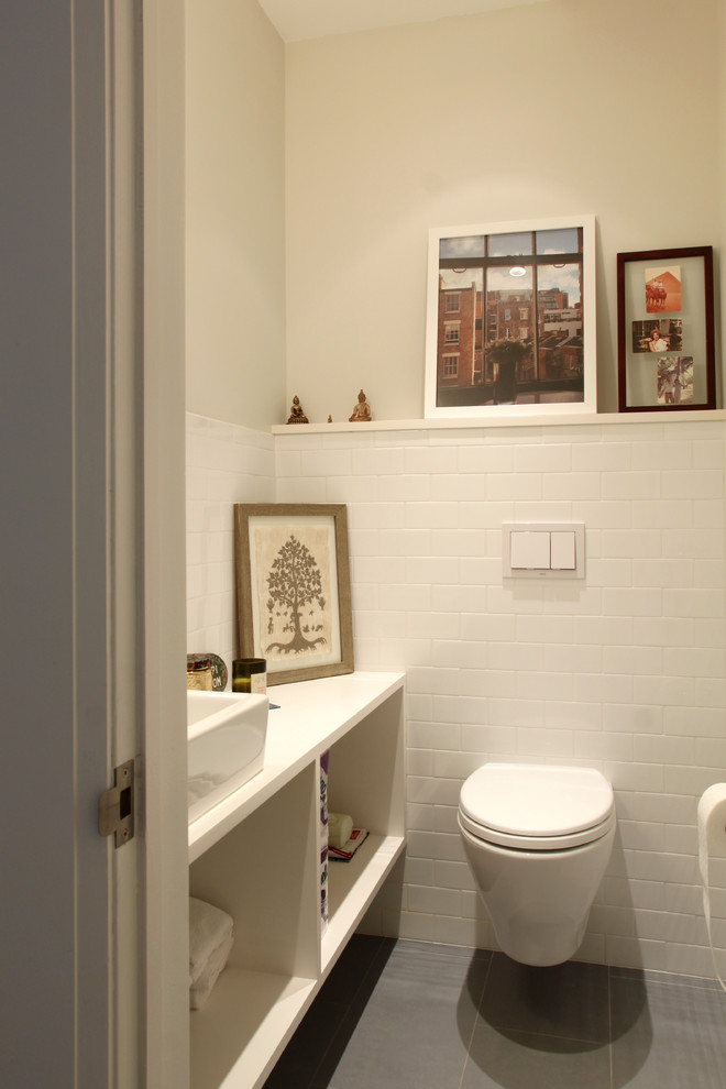 Moderne Gästetoilette mit Aufsatzwaschbecken, weißen Schränken, Waschtisch aus Holz, Wandtoilette, grauen Fliesen, weißen Fliesen, Porzellanfliesen, weißer Wandfarbe und Porzellan-Bodenfliesen in New York