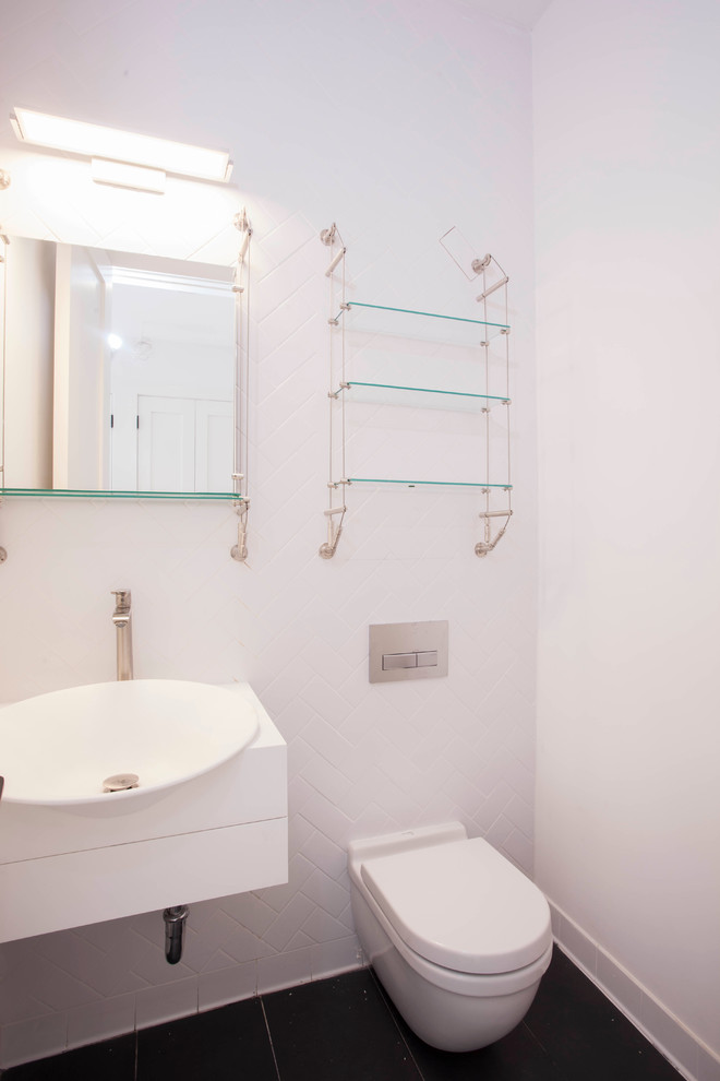 Exemple d'un WC et toilettes moderne de taille moyenne avec un lavabo suspendu, un placard à porte plane, des portes de placard blanches, WC à poser, un carrelage blanc, un carrelage métro, un mur blanc et un sol en carrelage de porcelaine.