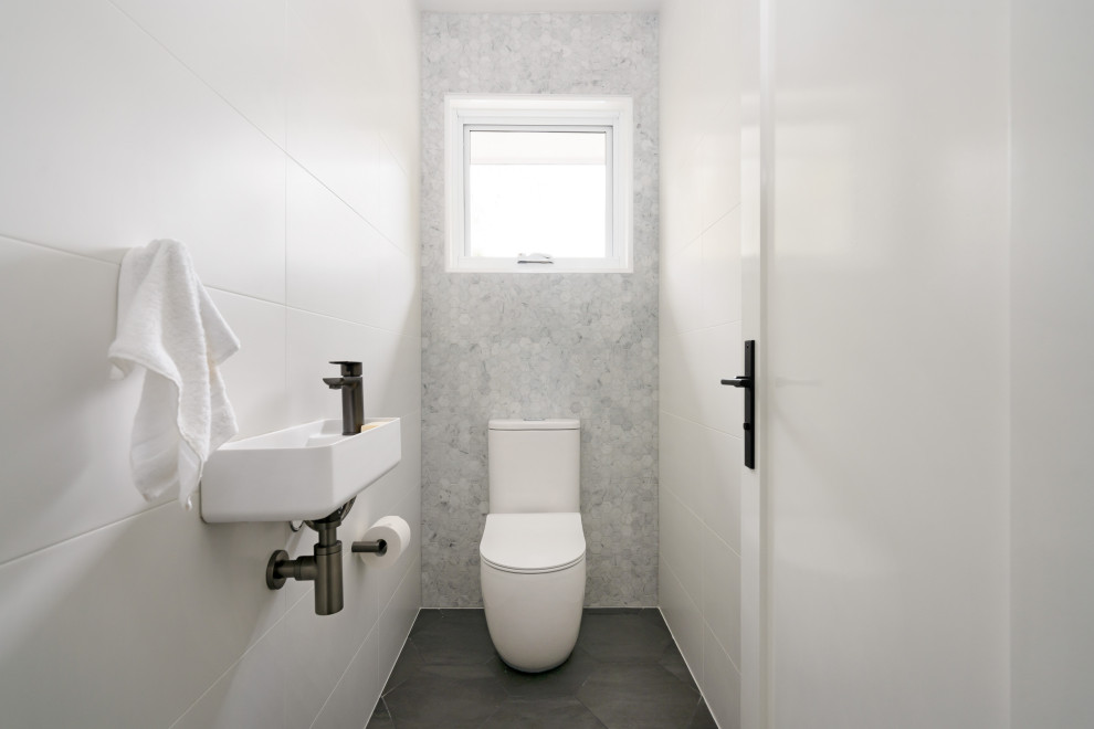 Inredning av ett modernt toalett, med grått golv