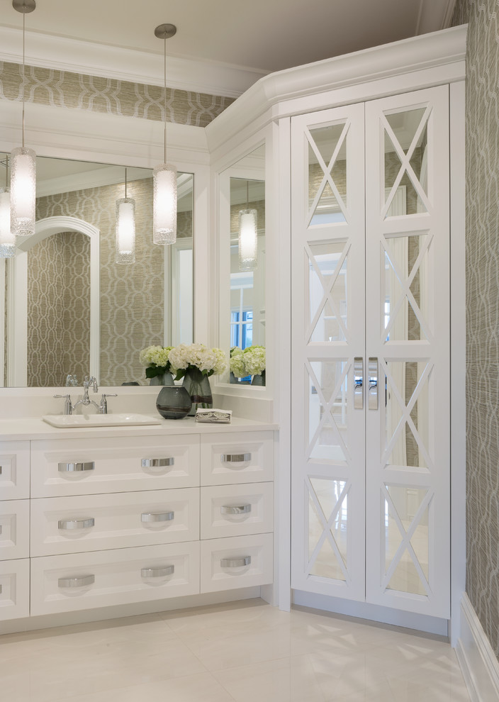 Inspiration for a mid-sized mediterranean white floor and ceramic tile powder room remodel in Miami with glass-front cabinets, white cabinets, multicolored walls, a drop-in sink, quartzite countertops and white countertops