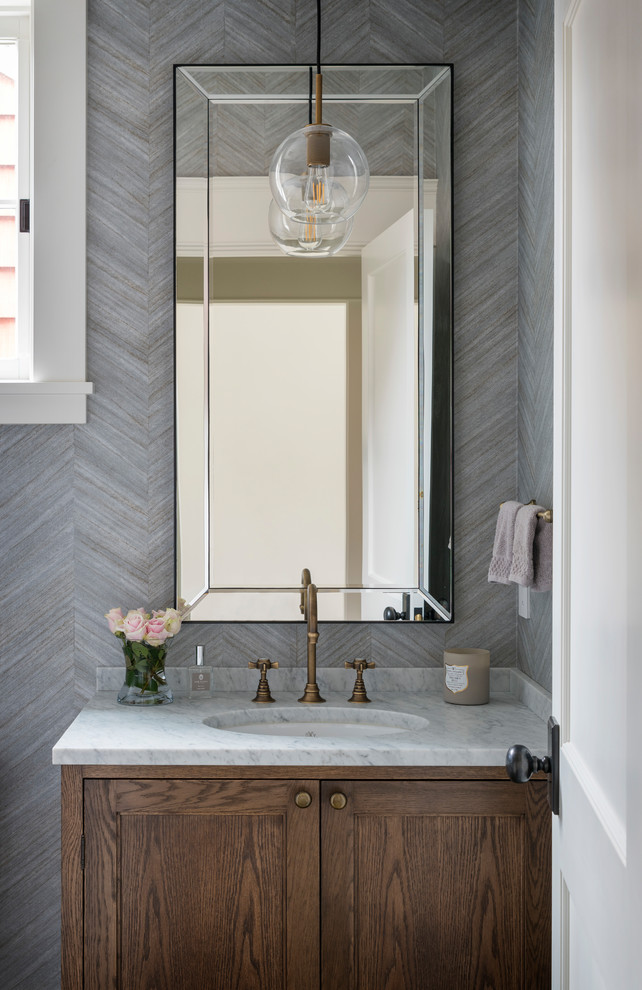 Foto di un bagno di servizio classico con ante con riquadro incassato, ante in legno bruno, pareti grigie, lavabo sottopiano e top bianco