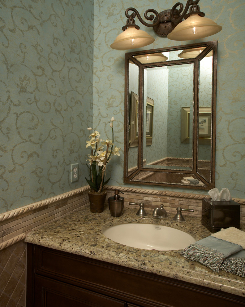 Пример оригинального дизайна: туалет среднего размера в классическом стиле с фасадами с выступающей филенкой, темными деревянными фасадами, бежевой плиткой, каменной плиткой, синими стенами, врезной раковиной и столешницей из гранита