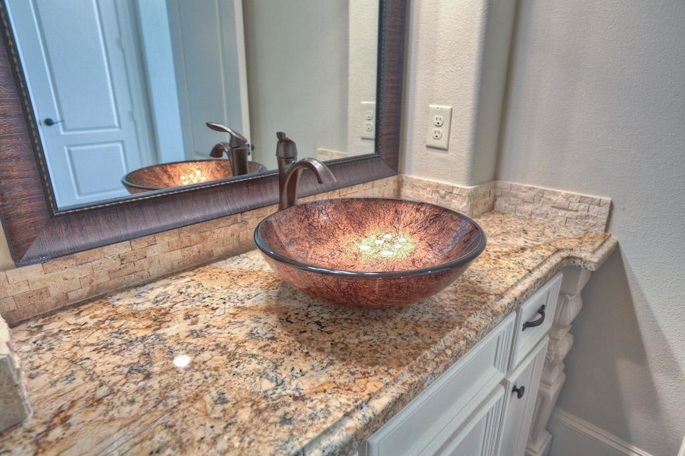 Imagen de aseo clásico con lavabo sobreencimera y encimera de granito