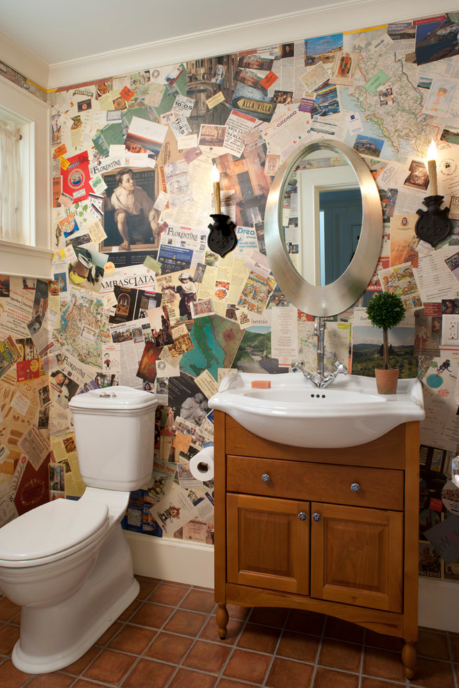 Powder room - traditional orange tile terra-cotta tile powder room idea in Other with an integrated sink, raised-panel cabinets, medium tone wood cabinets, a two-piece toilet and multicolored walls