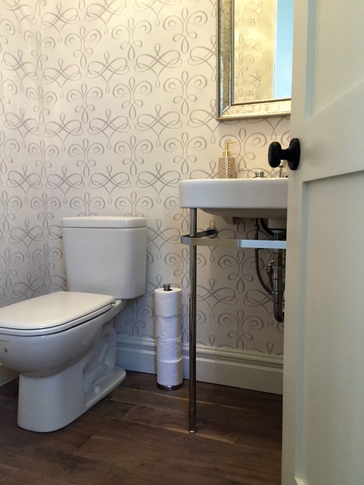 Cette image montre un WC et toilettes traditionnel de taille moyenne avec un mur beige et un sol en bois brun.