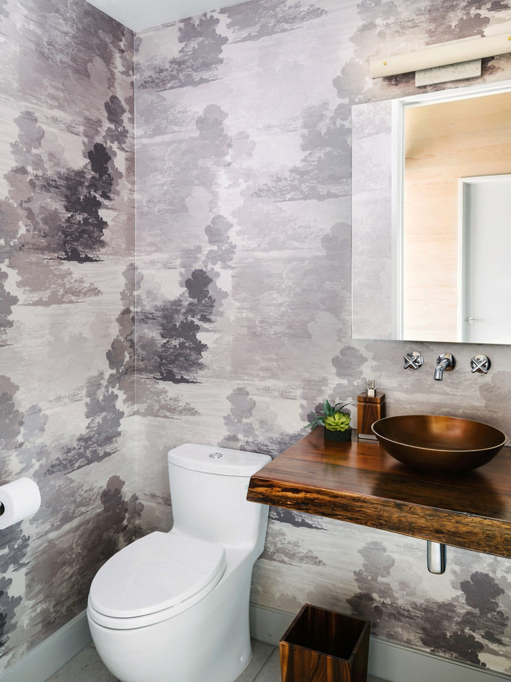 Ejemplo de aseo de estilo de casa de campo con sanitario de una pieza, paredes grises, lavabo sobreencimera, encimera de madera, suelo gris y encimeras marrones