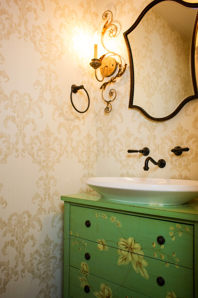 Foto på ett litet vintage toalett, med möbel-liknande, gröna skåp, en toalettstol med separat cisternkåpa, beige väggar och träbänkskiva