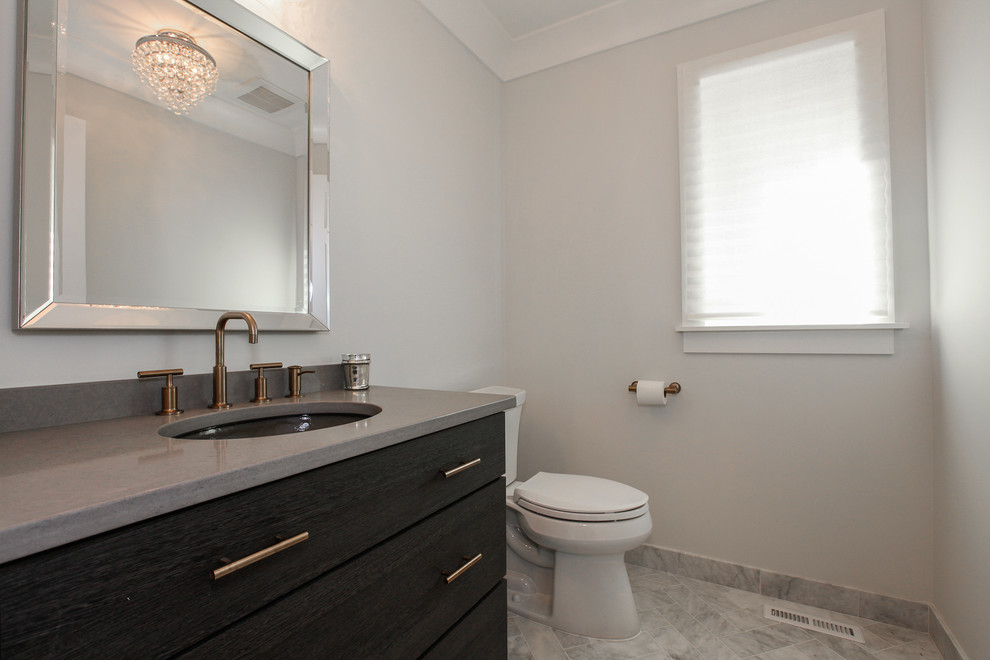 This is an example of a medium sized farmhouse cloakroom in Chicago with grey walls, marble flooring, a submerged sink, grey floors, freestanding cabinets, black cabinets, a two-piece toilet, concrete worktops and grey worktops.