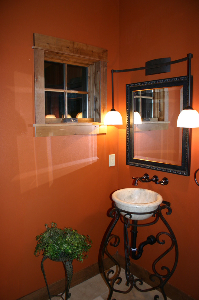 На фото: туалет в стиле рустика с раковиной с пьедесталом и оранжевыми стенами