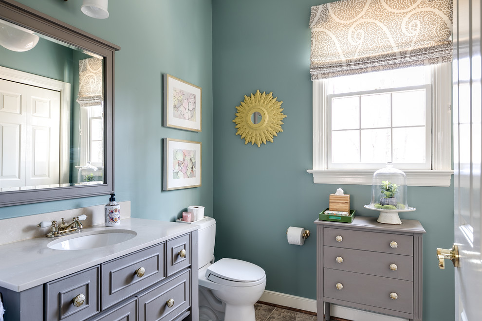 Esempio di un bagno di servizio chic con consolle stile comò, ante grigie, WC a due pezzi, pareti blu, lavabo sottopiano e top grigio