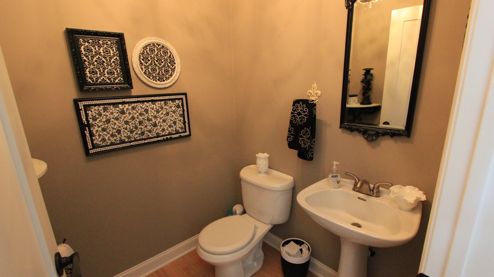 Mittelgroße Stilmix Gästetoilette mit Wandtoilette mit Spülkasten, beiger Wandfarbe, braunem Holzboden, Sockelwaschbecken, Mineralwerkstoff-Waschtisch, beigem Boden und weißer Waschtischplatte in Minneapolis