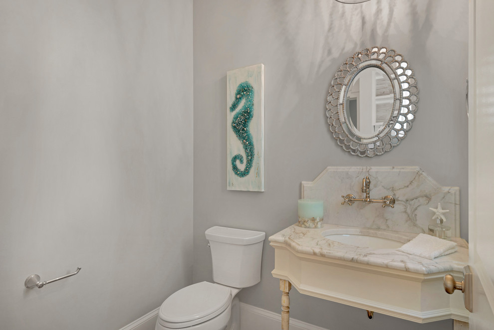 Immagine di un piccolo bagno di servizio costiero con WC a due pezzi, piastrelle multicolore, lastra di pietra, pareti grigie, pavimento in legno massello medio, top in marmo e lavabo sottopiano