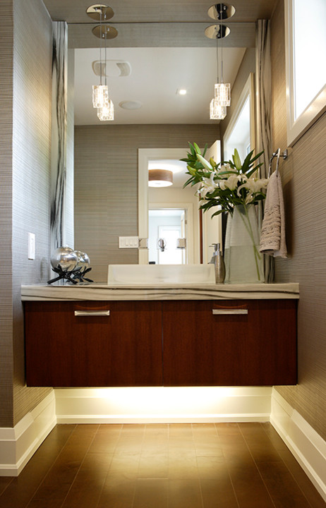 Aménagement d'un WC et toilettes contemporain en bois foncé de taille moyenne avec un placard à porte plane, un mur beige, un sol en bois brun, une vasque et un plan de toilette en marbre.