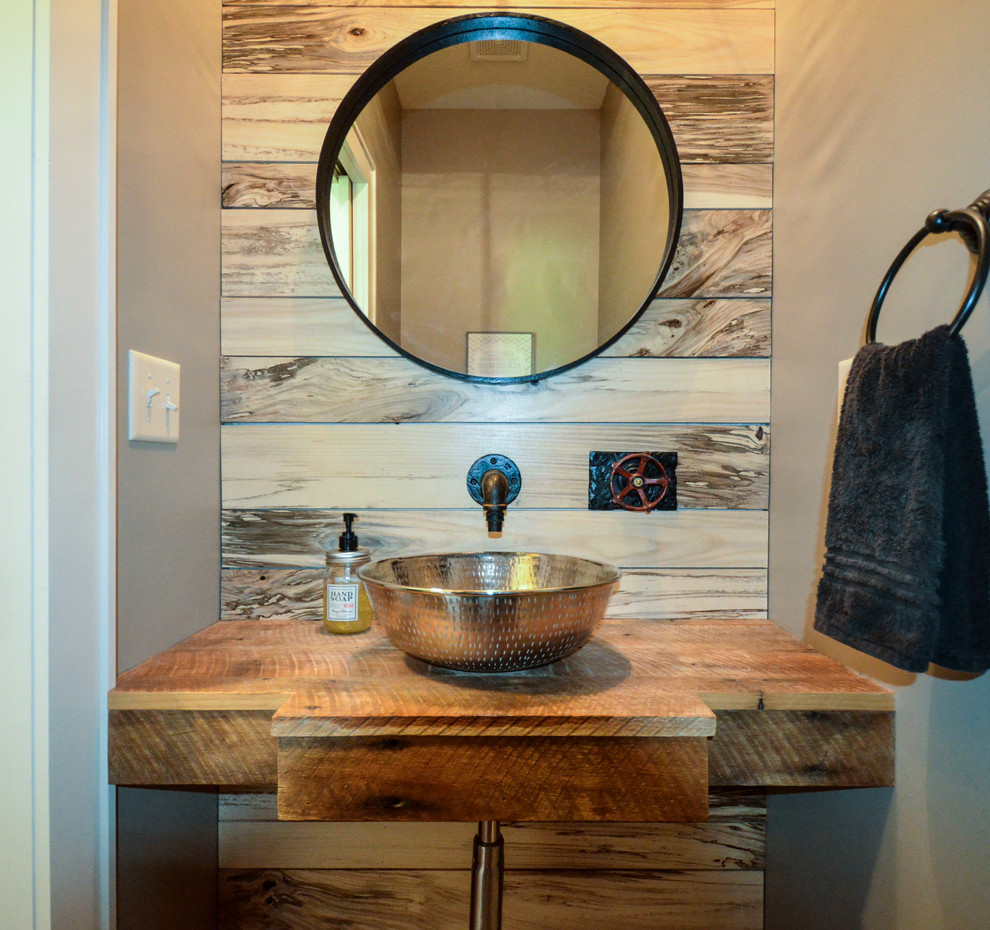 Inspiration for a mid-sized rustic ceramic tile powder room remodel in Kansas City with a vessel sink, wood countertops, beige walls and brown countertops