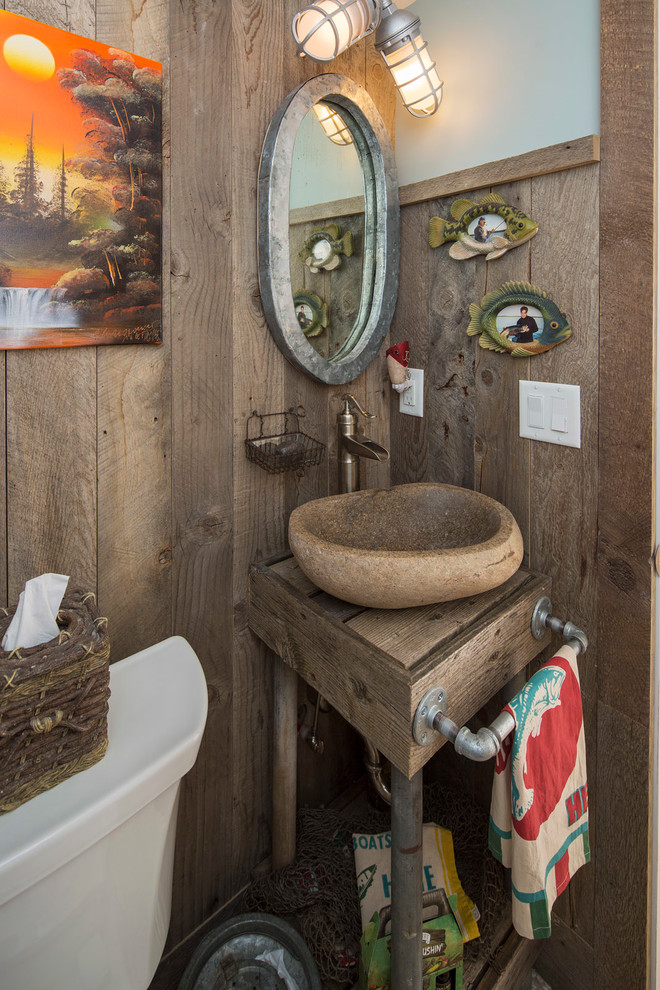 Foto på ett maritimt toalett, med ett fristående handfat och träbänkskiva