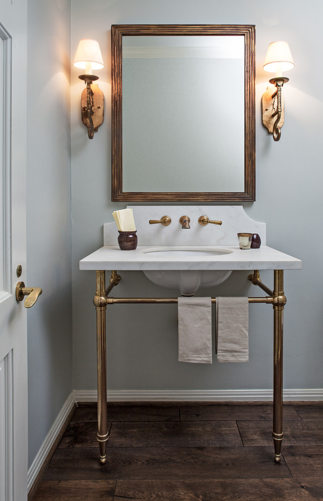 Inspiration pour un WC et toilettes traditionnel avec un mur gris, un sol en bois brun, un lavabo encastré, un plan de toilette en marbre et un sol marron.