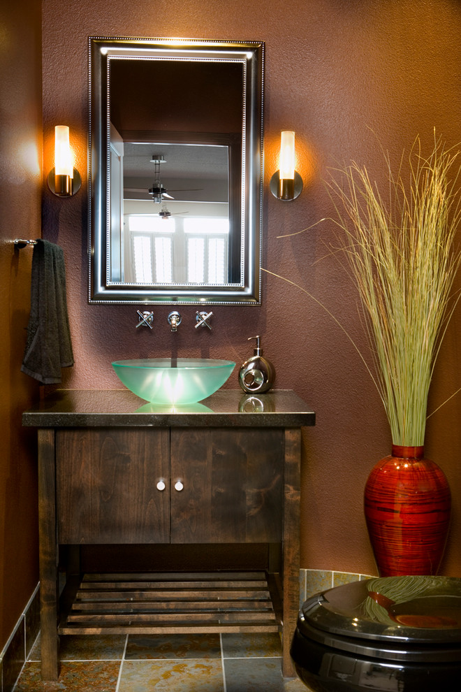 Example of a small trendy ceramic tile powder room design in Boise with a vessel sink, furniture-like cabinets, dark wood cabinets, granite countertops, a two-piece toilet and brown walls