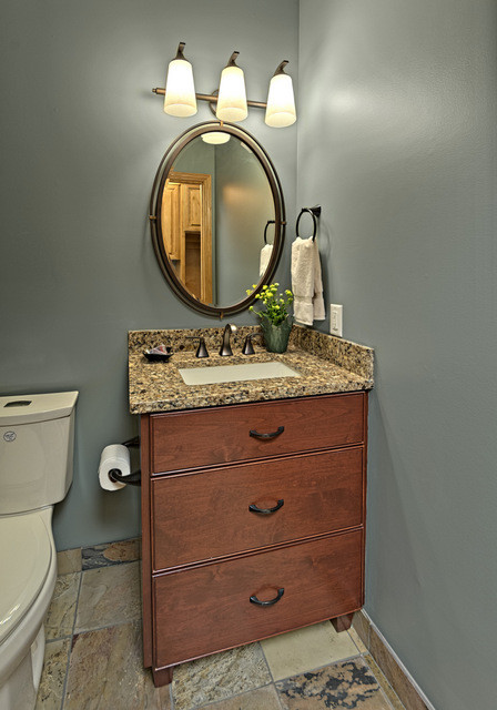 Inredning av ett amerikanskt litet flerfärgad flerfärgat toalett, med möbel-liknande, skåp i mörkt trä, en toalettstol med hel cisternkåpa, grå väggar, skiffergolv, ett undermonterad handfat, granitbänkskiva och flerfärgat golv