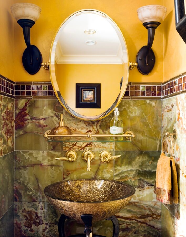 На фото: туалет в средиземноморском стиле с коричневой плиткой, зеленой плиткой, желтыми стенами и настольной раковиной с