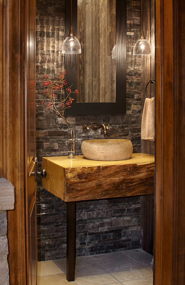 デンバーにあるラスティックスタイルのおしゃれなトイレ・洗面所 (ベッセル式洗面器、木製洗面台、グレーのタイル、石タイル) の写真