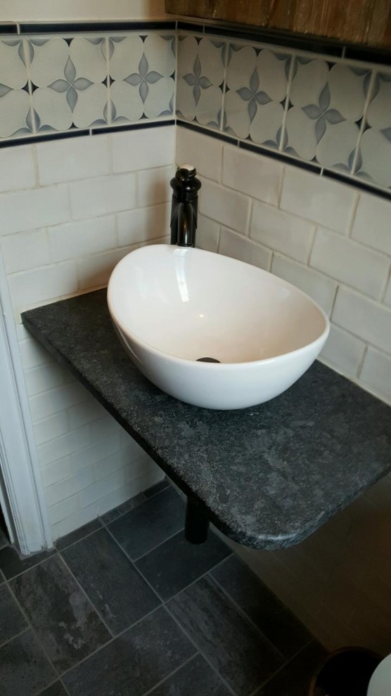 Cette image montre un petit WC et toilettes design avec un carrelage blanc, un carrelage métro, un mur multicolore, un sol en ardoise, une vasque, un plan de toilette en granite, un sol gris et un plan de toilette gris.