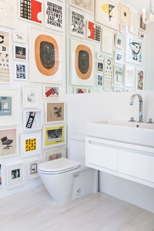 Skandinavische Gästetoilette mit flächenbündigen Schrankfronten, weißen Schränken, Toilette mit Aufsatzspülkasten und hellem Holzboden in New York