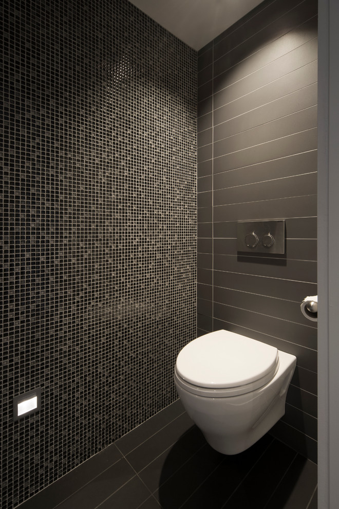 Aménagement d'un petit WC suspendu contemporain en bois brun avec un placard à porte plane, un carrelage gris, un mur gris, un sol en carrelage de céramique, un plan de toilette en granite et mosaïque.