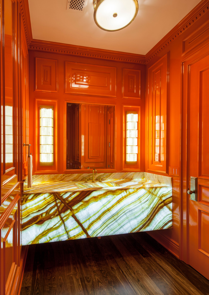 Cette photo montre un WC et toilettes chic de taille moyenne avec des portes de placard oranges, un mur orange et un sol en bois brun.
