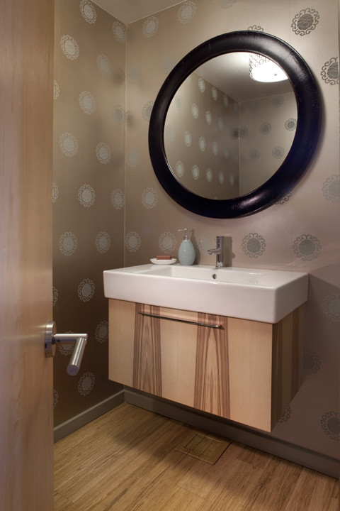 Ejemplo de aseo contemporáneo pequeño con lavabo suspendido, puertas de armario de madera clara, paredes grises y suelo de madera clara