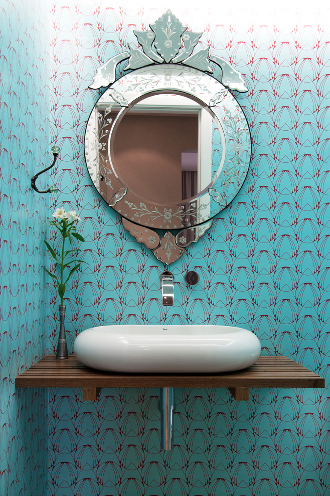 Идея дизайна: туалет в стиле неоклассика (современная классика) с настольной раковиной, столешницей из дерева, синими стенами и коричневой столешницей