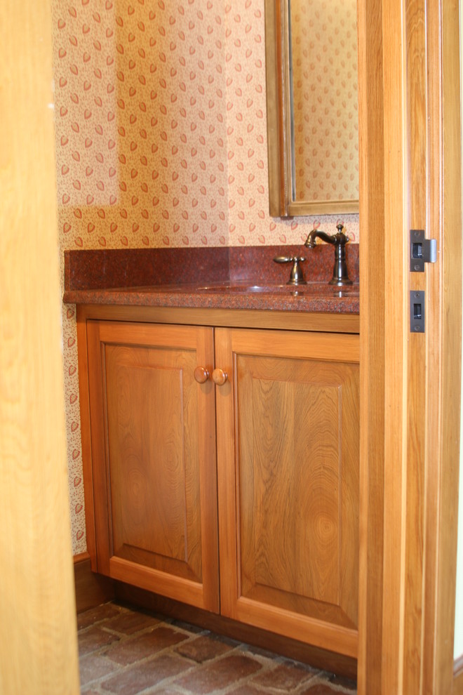ニューオリンズにある小さなラスティックスタイルのおしゃれなトイレ・洗面所 (アンダーカウンター洗面器、レイズドパネル扉のキャビネット、中間色木目調キャビネット、クオーツストーンの洗面台) の写真