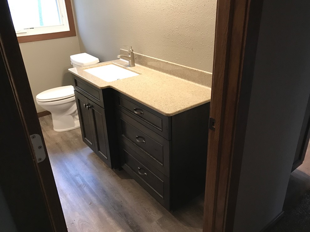 Inspiration for a mid-sized timeless light wood floor powder room remodel in Other with shaker cabinets, dark wood cabinets, a one-piece toilet, beige walls, an undermount sink and granite countertops
