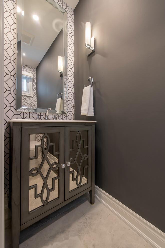 This is an example of a small contemporary cloakroom in Toronto with glass-front cabinets, grey cabinets, a one-piece toilet, grey walls, ceramic flooring, a submerged sink, solid surface worktops and beige floors.