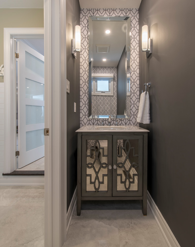 Inspiration for a small contemporary ceramic tile and beige floor powder room remodel in Toronto with gray walls, an undermount sink, glass-front cabinets, gray cabinets, a one-piece toilet and solid surface countertops