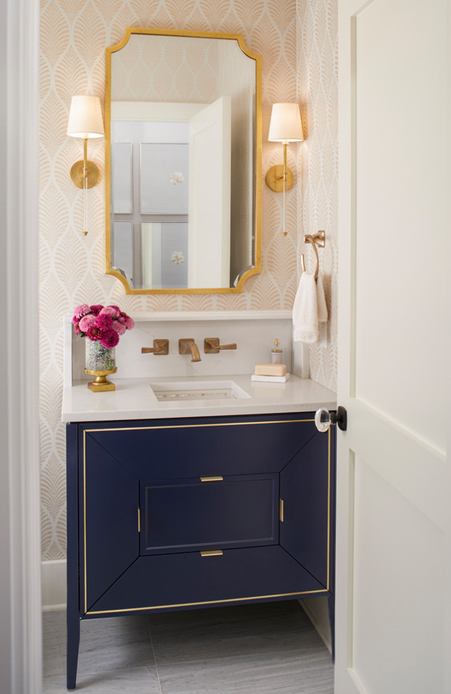 Photo of a traditional cloakroom in Boston with flat-panel cabinets, blue cabinets, beige walls, a submerged sink, grey floors, white worktops, a freestanding vanity unit and wallpapered walls.