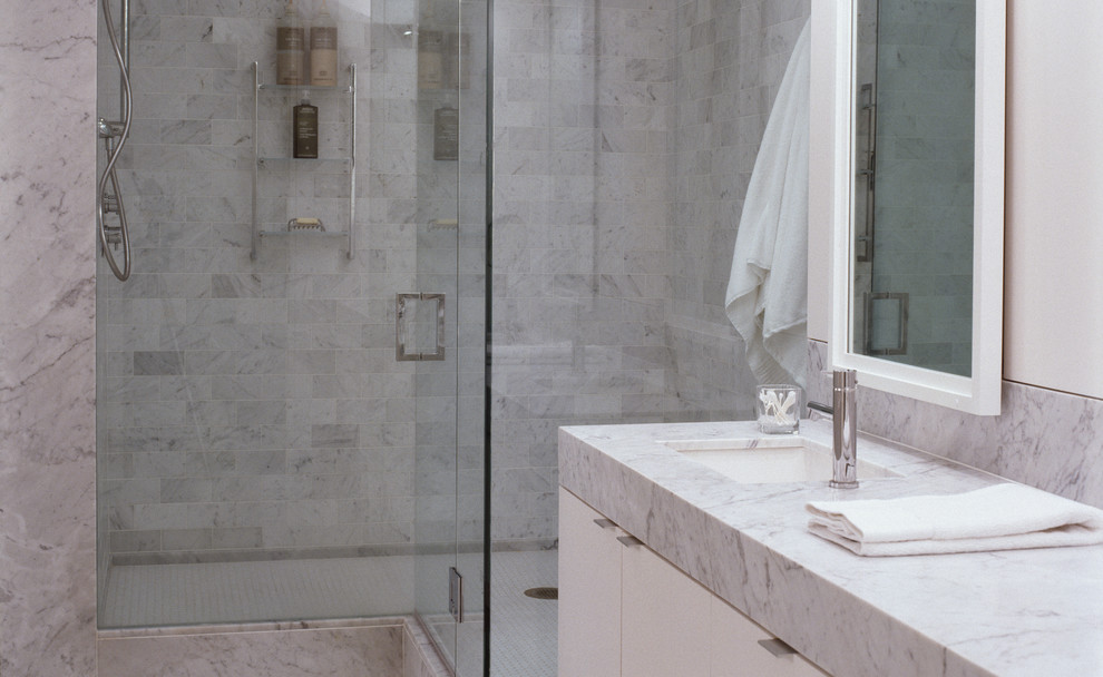 Foto di una stanza da bagno design con lavabo sottopiano e piastrelle in pietra