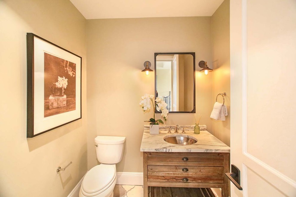 Medelhavsstil inredning av ett mellanstort beige beige toalett, med möbel-liknande, skåp i ljust trä, beige väggar, cementgolv, ett undermonterad handfat och flerfärgat golv