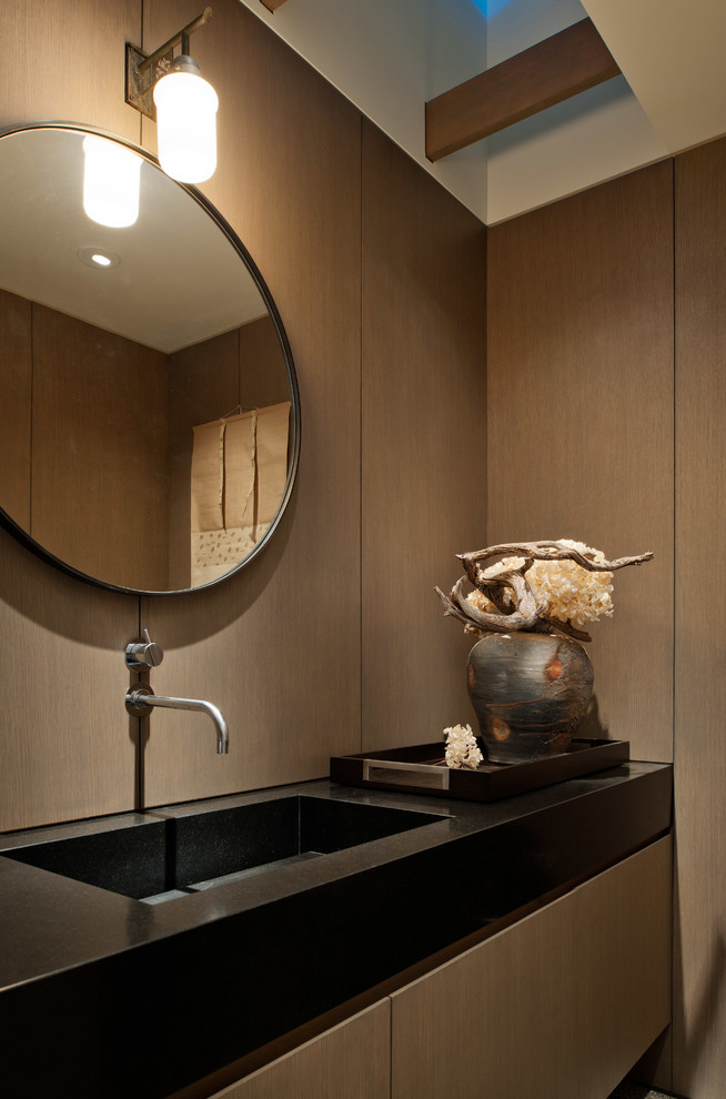Immagine di un bagno di servizio contemporaneo con lavabo integrato, ante lisce, ante in legno scuro e piastrelle nere