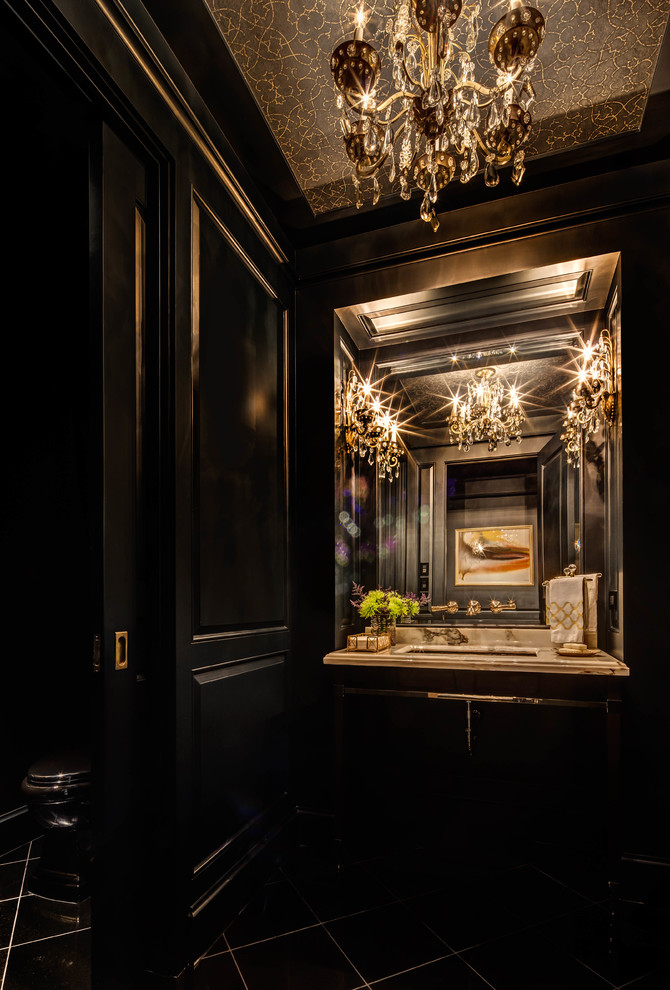Modelo de aseo clásico renovado con puertas de armario negras, paredes negras, lavabo bajoencimera, encimera de mármol, suelo negro, encimeras beige y suelo de mármol