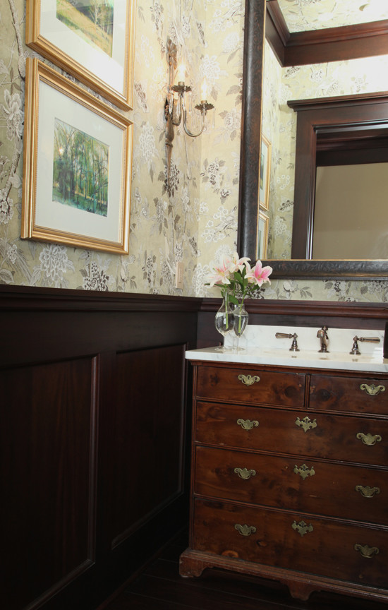 Inspiration pour un WC et toilettes traditionnel en bois brun de taille moyenne avec un plan de toilette en marbre et un sol en bois brun.