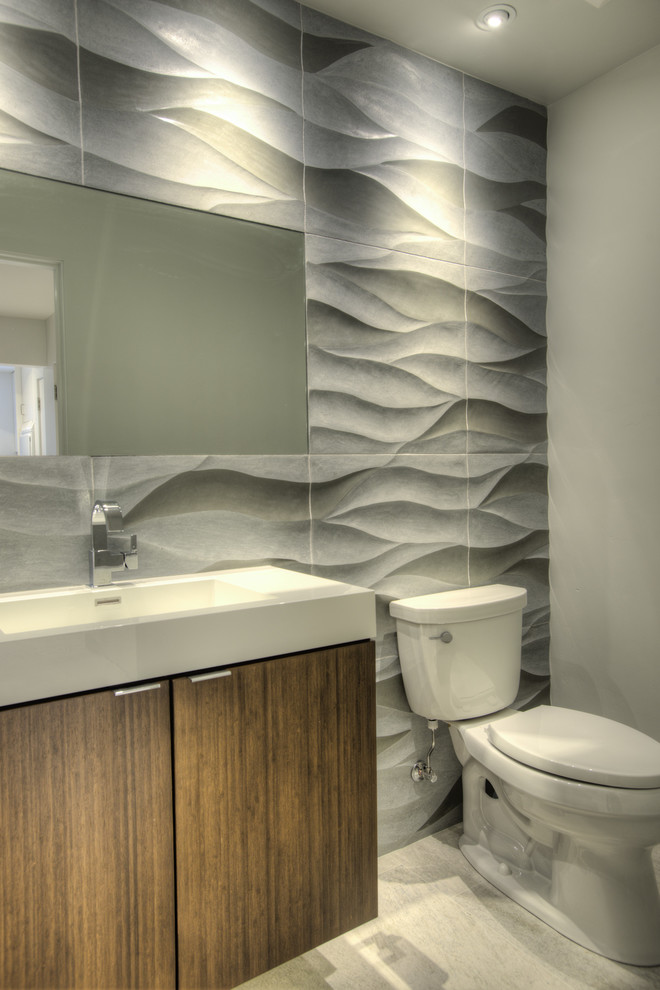 На фото: туалет в современном стиле с монолитной раковиной, плоскими фасадами и фасадами цвета дерева среднего тона с