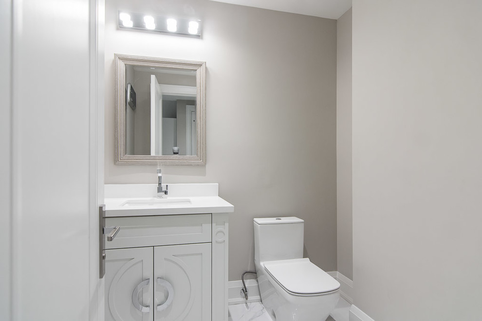 Mittelgroße Klassische Gästetoilette mit Schrankfronten mit vertiefter Füllung, weißen Schränken, Toilette mit Aufsatzspülkasten, grauer Wandfarbe, Marmorboden, Unterbauwaschbecken, Mineralwerkstoff-Waschtisch und weißem Boden in Toronto