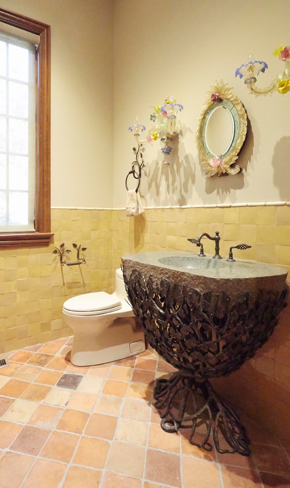 На фото: огромный туалет в классическом стиле с унитазом-моноблоком, бежевыми стенами и полом из терракотовой плитки