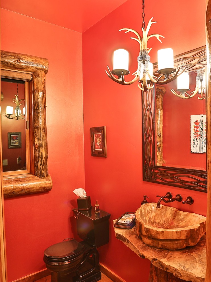 Cette image montre un WC et toilettes chalet avec une vasque, un plan de toilette en granite, WC à poser et un mur rouge.