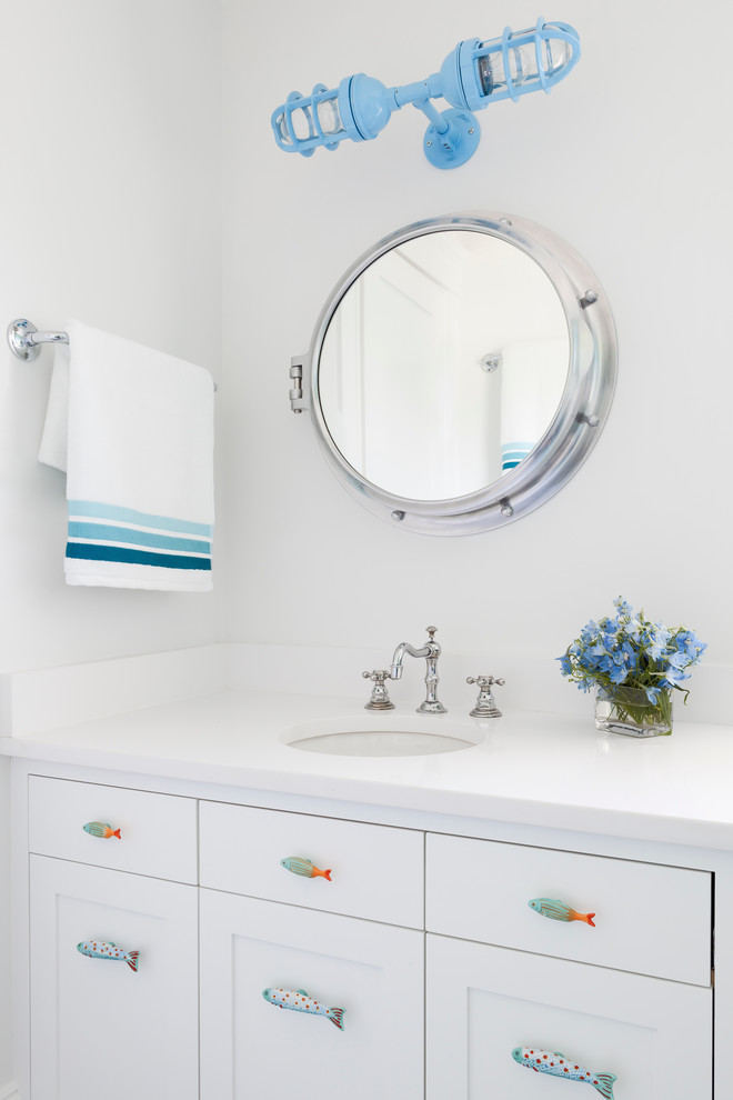 Immagine di un bagno di servizio stile marinaro con lavabo sottopiano, ante in stile shaker, ante bianche e top bianco