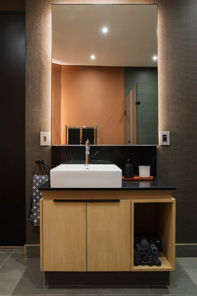 Medium sized contemporary cloakroom in Other with flat-panel cabinets, beige cabinets, grey walls, porcelain flooring, a vessel sink, grey floors, black worktops and a built in vanity unit.