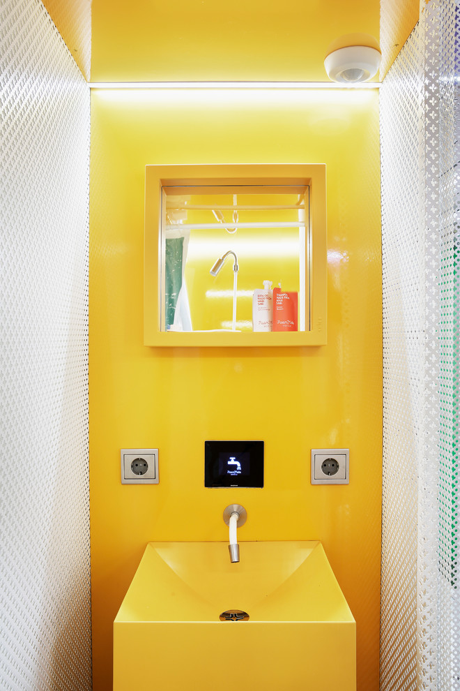 Идея дизайна: маленький туалет в современном стиле с подвесной раковиной и желтыми стенами для на участке и в саду